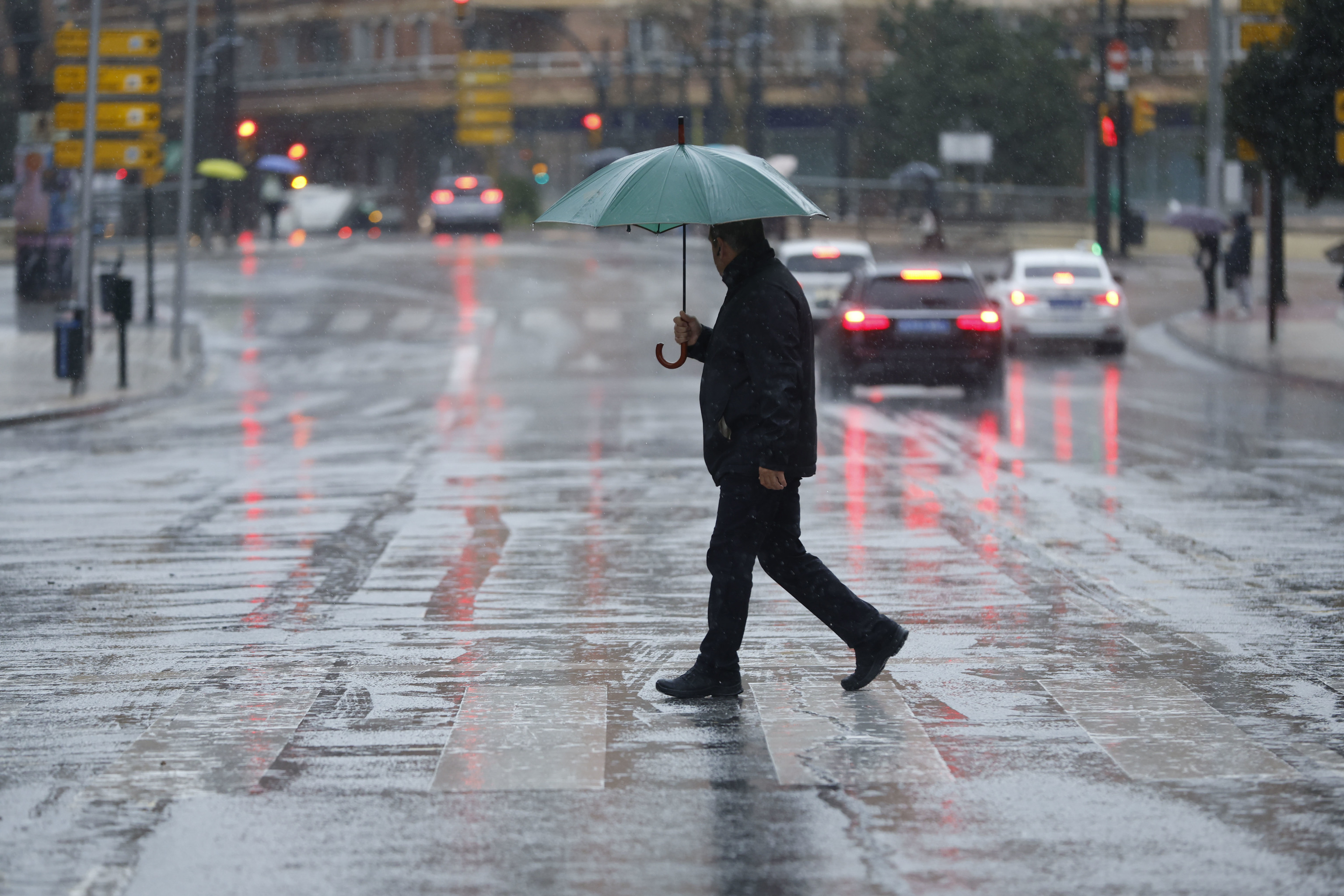 Un ciudadano pasea bajo la lluvia en M�laga