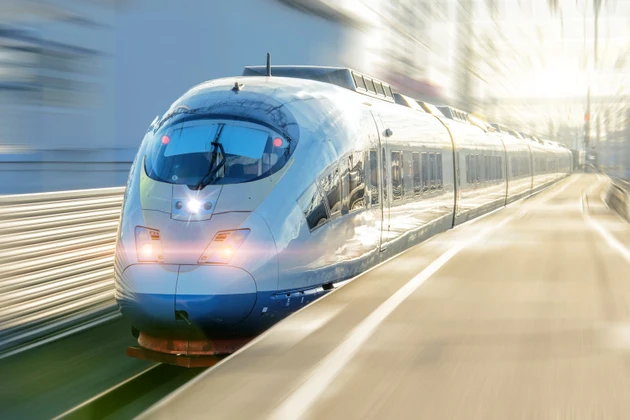 Electric passenger train drives at high speed departs from the platform.