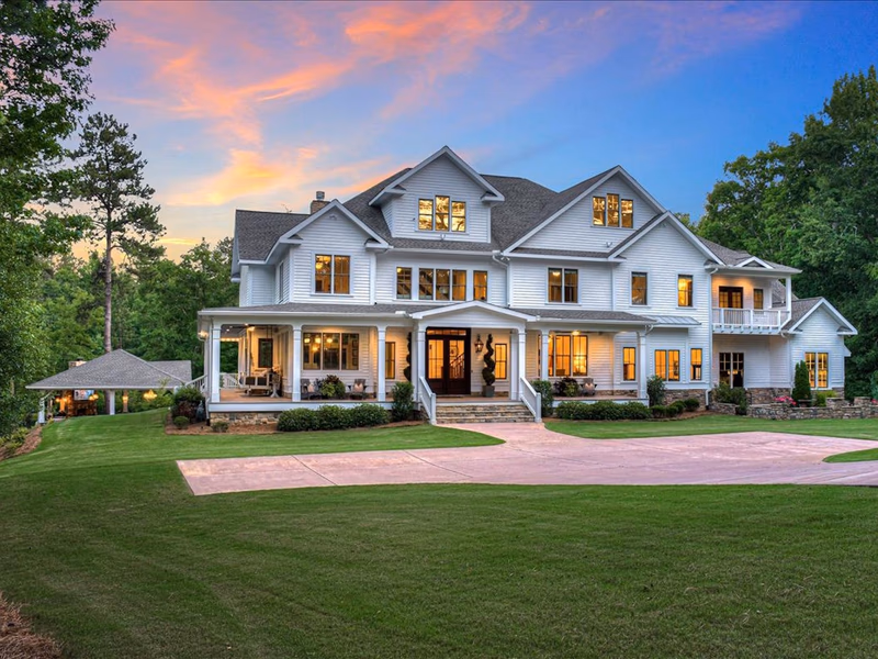 A large white house with a large green lawn.