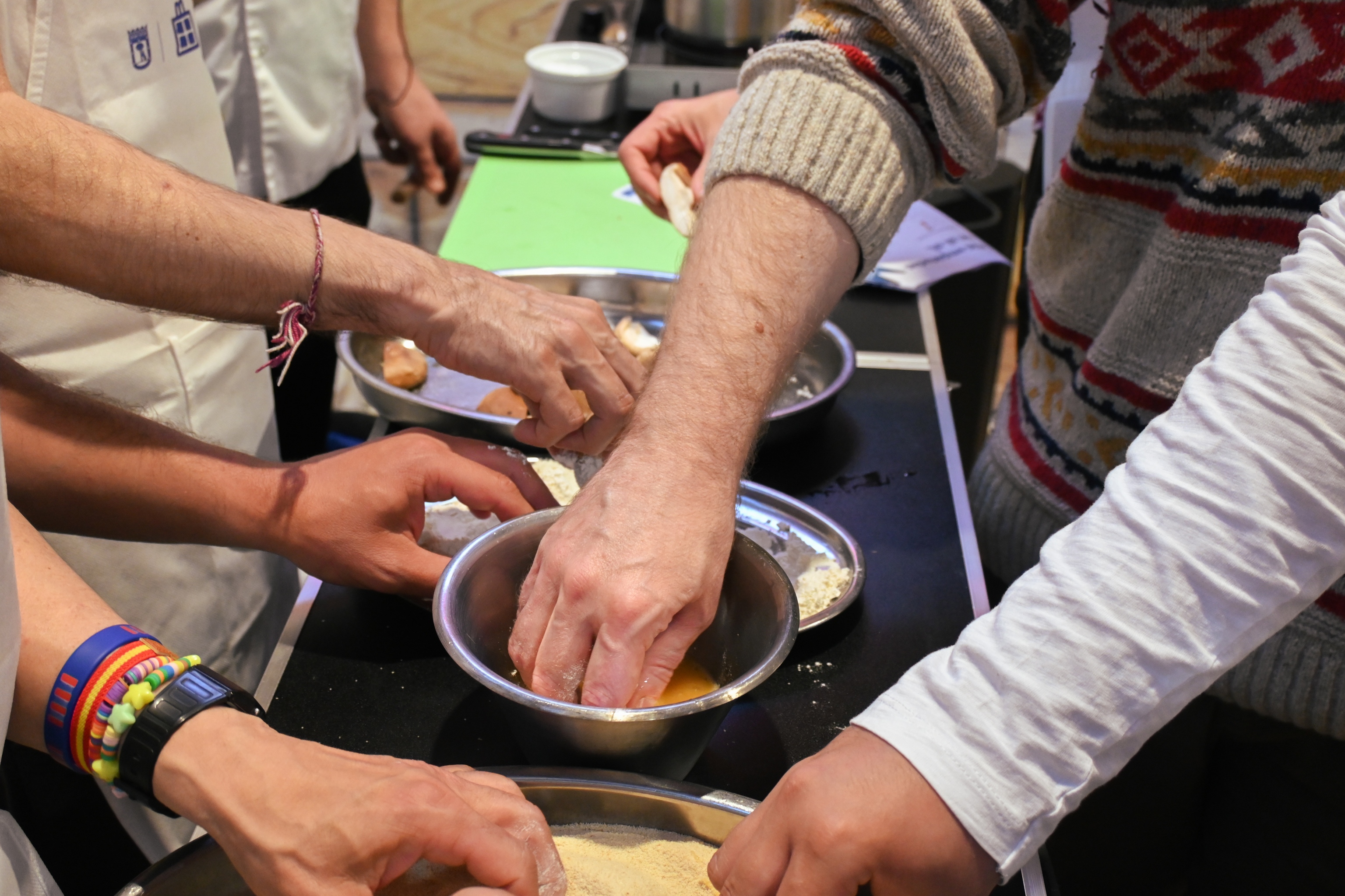 Las manos de los seis asistentes a las clases de cocina.