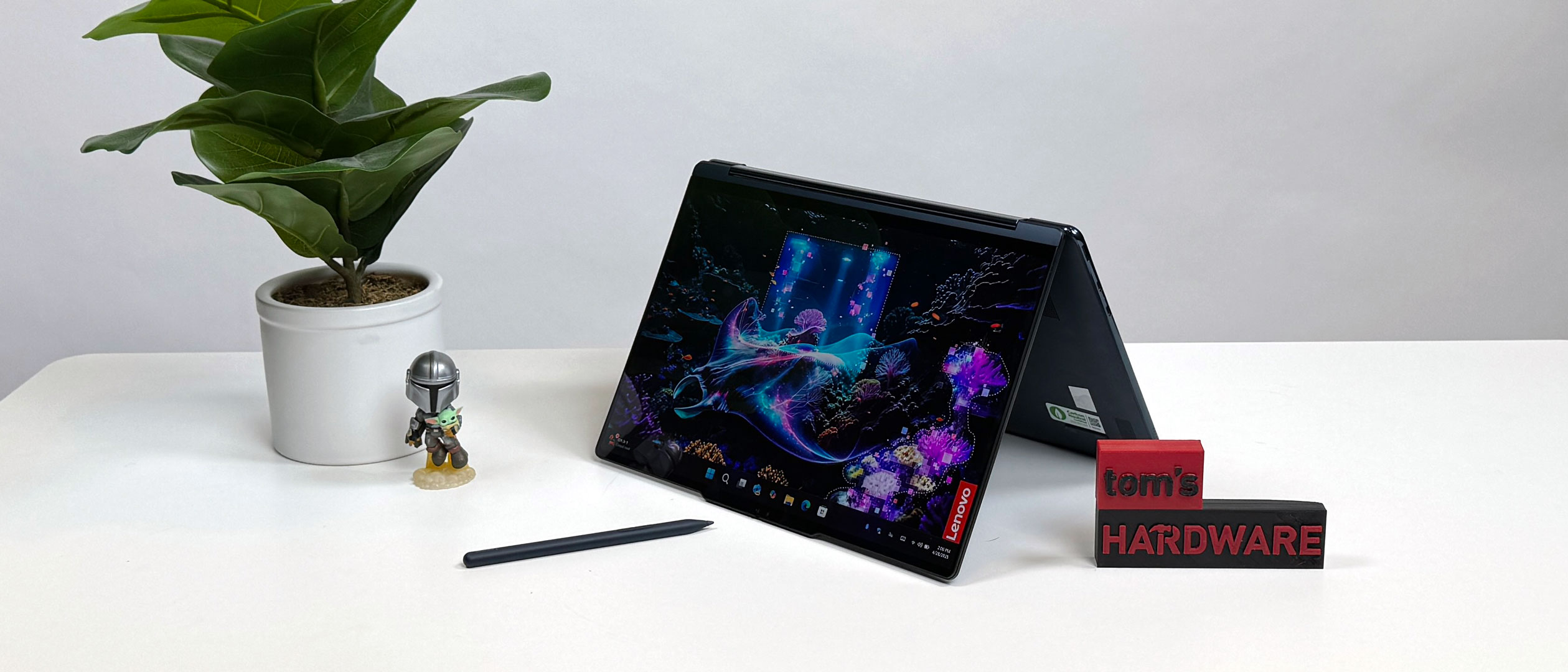 The Lenovo Yoga 9i 2-in-1 Aura Edition in tent mode on a desk. Its strong chassis can handle being flipped back and forth all the time.