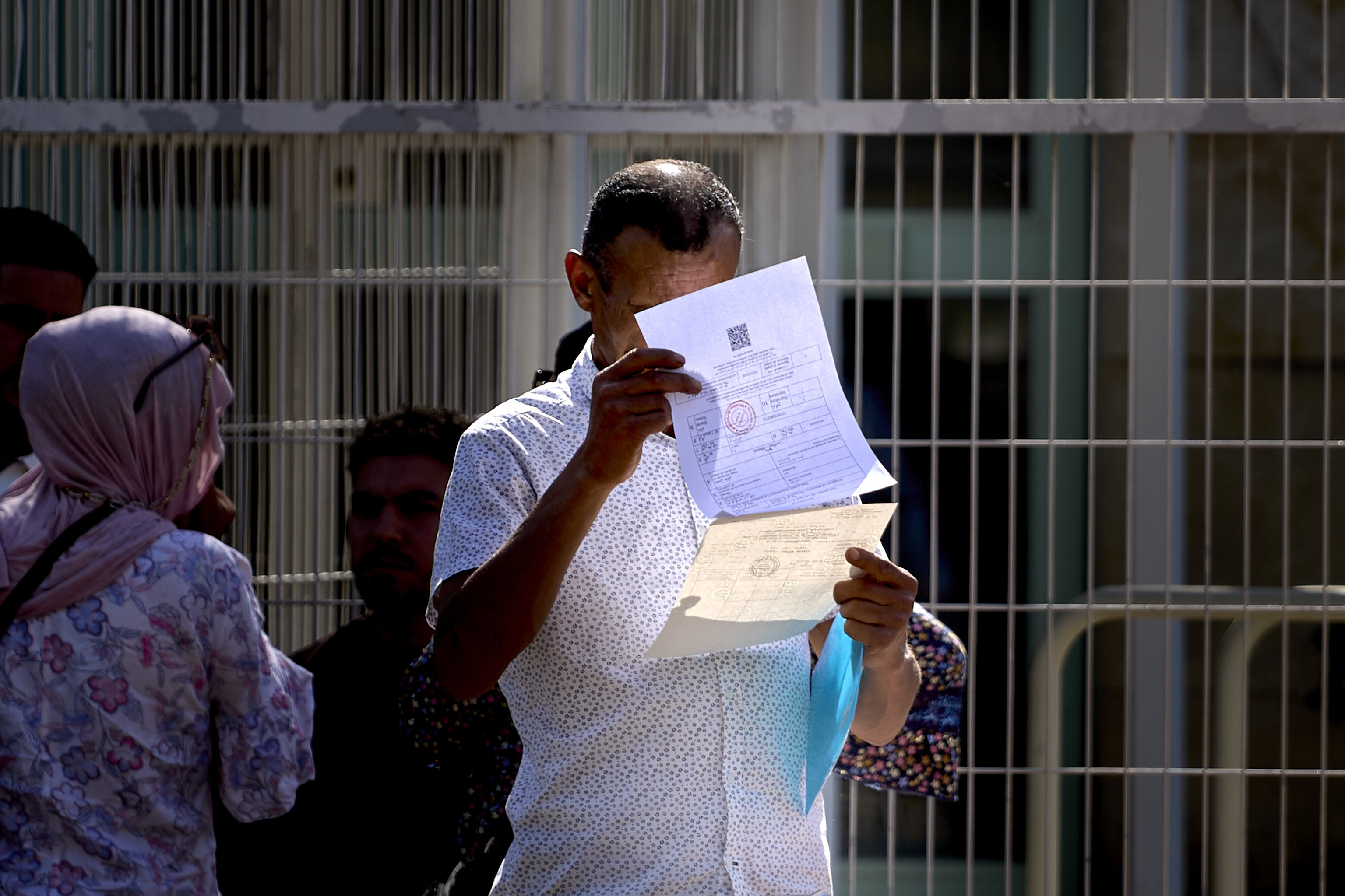 Un hombre revisa sus documentos tras salir del consulado de Marruecos en Sevilla.