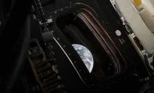 One half of the Earth is seen floating in space through the open door of the Orion spacecraft.