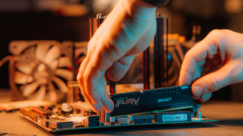 A shot of RAM being inserted into a motherboard