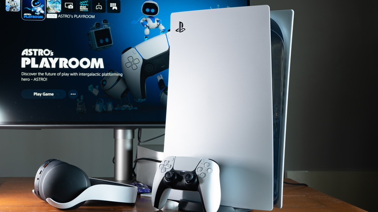 A PS5 console, controller, headset and monitor placed on a table