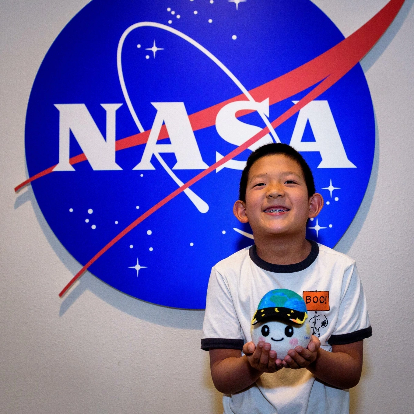Lucas Ye, 8, hold Rise, a plush toy that doubles as a zero-gravity indicator. Photo courtesy of NASA