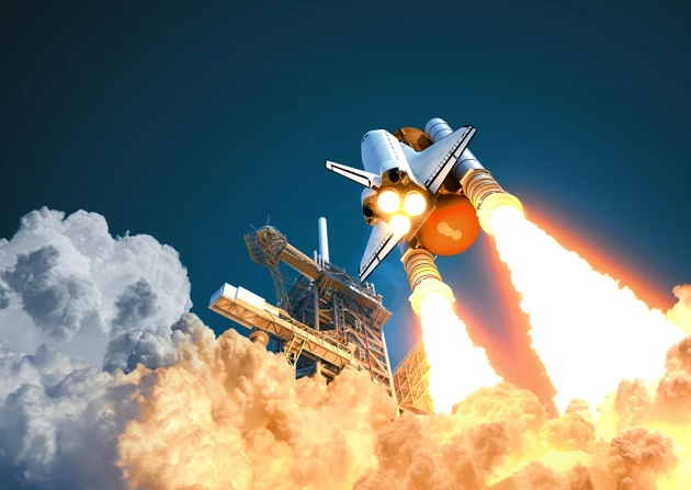 Space Shuttle hebt vor dem Hintergrund des blauen Himmels ab