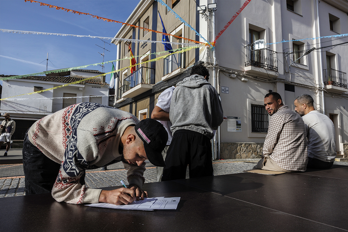 Varios inmigrantes irregulares rellenan la solicitud de regularización a las puertas del Ayuntamiento de Talayuela (Cáceres), este pasado miércoles.