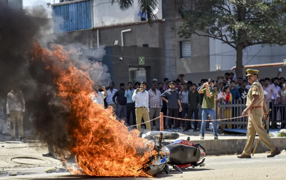 A police bike set on fire during a protest demanding wage hikes, in Noida on April 13, 2026.