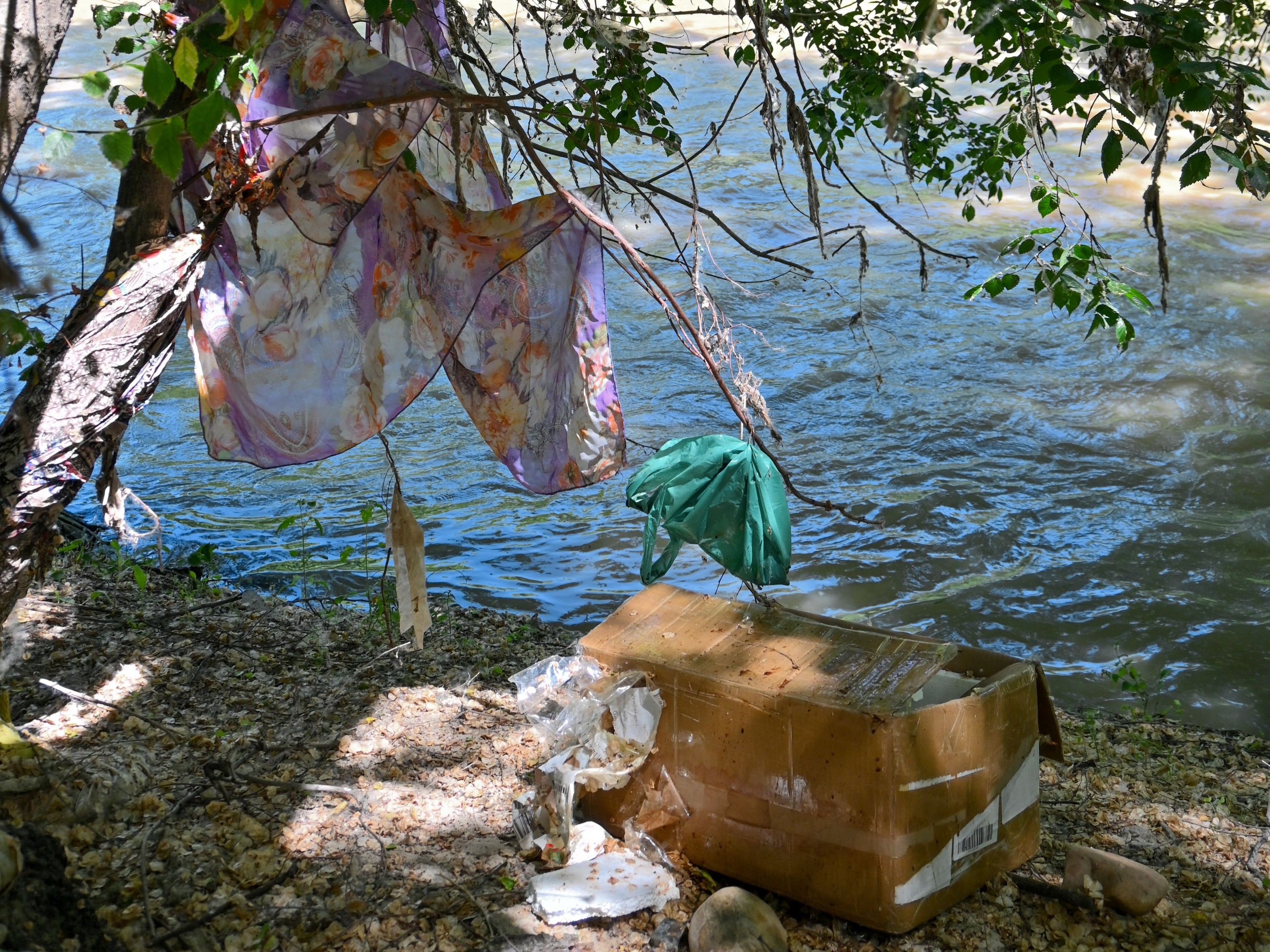 Restos de ropa, bolsas de pl�stico y cart�n a la orilla del r�o.