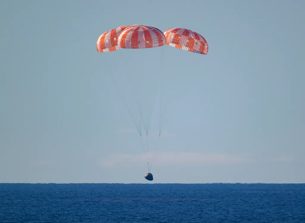 NASA’s Orion spacecraft with Artemis II crewmembers NASA astronauts Reid Wiseman, commander; Victor Glover, pilot; Christina Koch, mission specialist; and CSA (Canadian Space Agency) astronaut Jeremy Hansen, mission specialist aboard is seen under parachutes as it lands in the Pacific Ocean off the coast of California, Friday, April 10, 2026. NASA’s Artemis II mission took Wiseman, Glover, Koch, and Hansen on a 10-day journey around the Moon and back to Earth. Following a splashdown at 8:07 p.m. EDT, NASA, U.S. Navy, and U.S. Air Force teams are working to bring the crewmembers and Orion spacecraft aboard USS John P. Murtha.