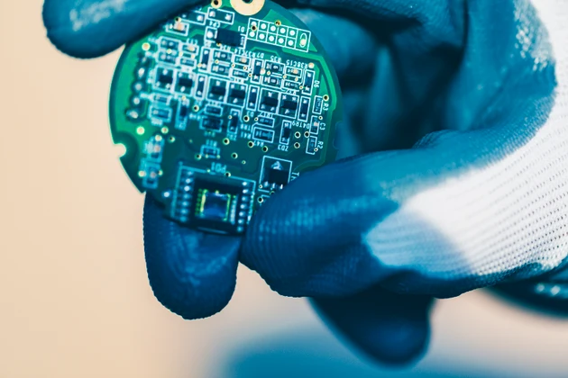 Blury AI brain chip in developer "s hand on blue background, artificial intelelligence development concept.