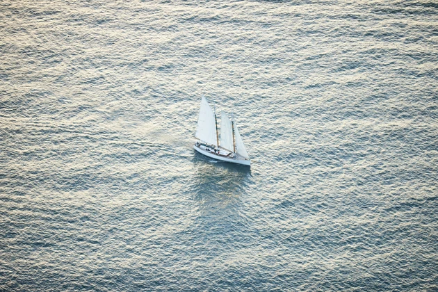 Aerial photo of small sailboat, sailing on a beautiful sunny day