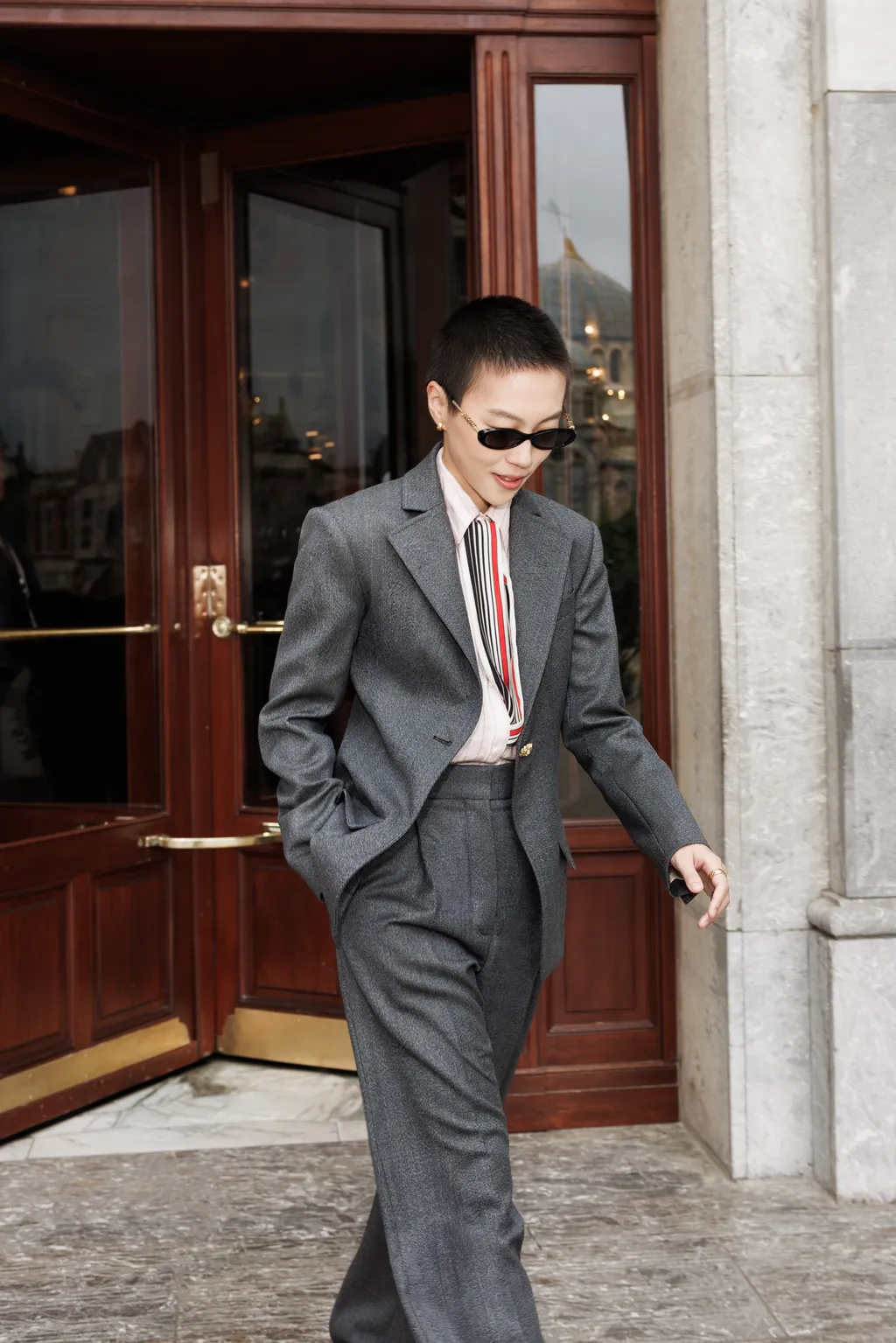 Image may contain Leah Dou Blazer Clothing Coat Formal Wear Jacket Suit Adult Person and Door