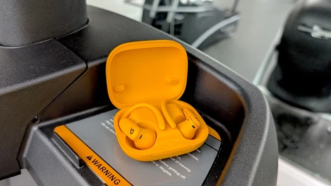 orange powerbeats pro sitting on workout equipment