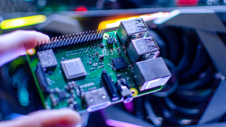 Fingers holding a Raspberry Pi micro computer