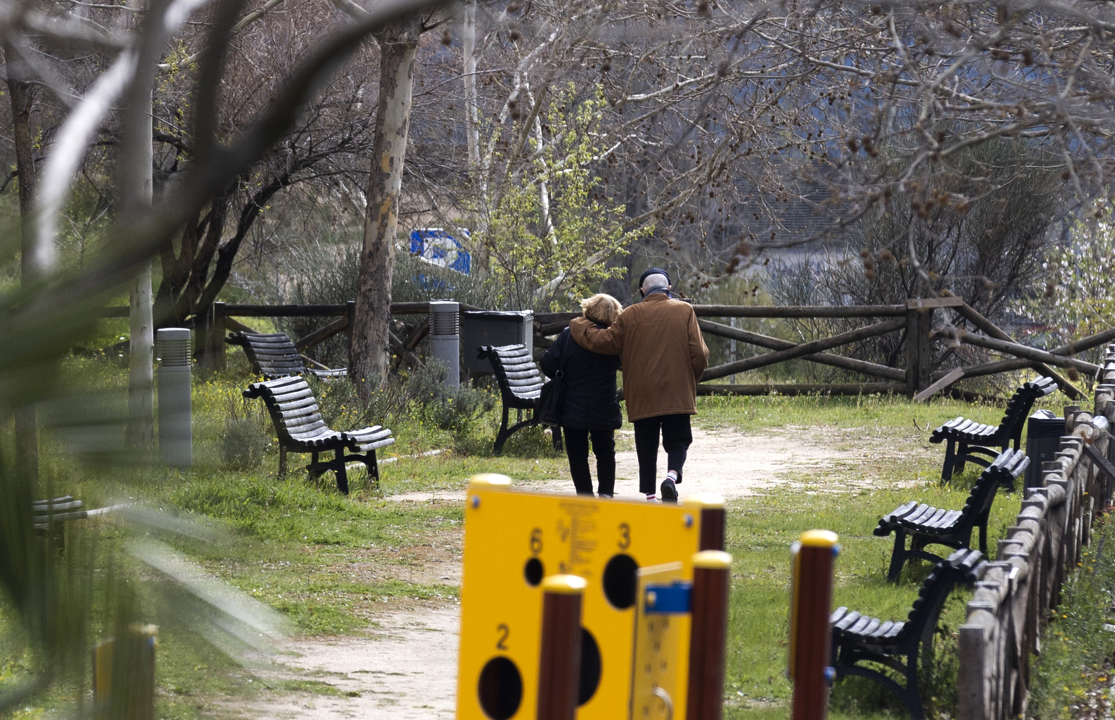 Una pareja de personas mayores pasea por un parque en Madrid.