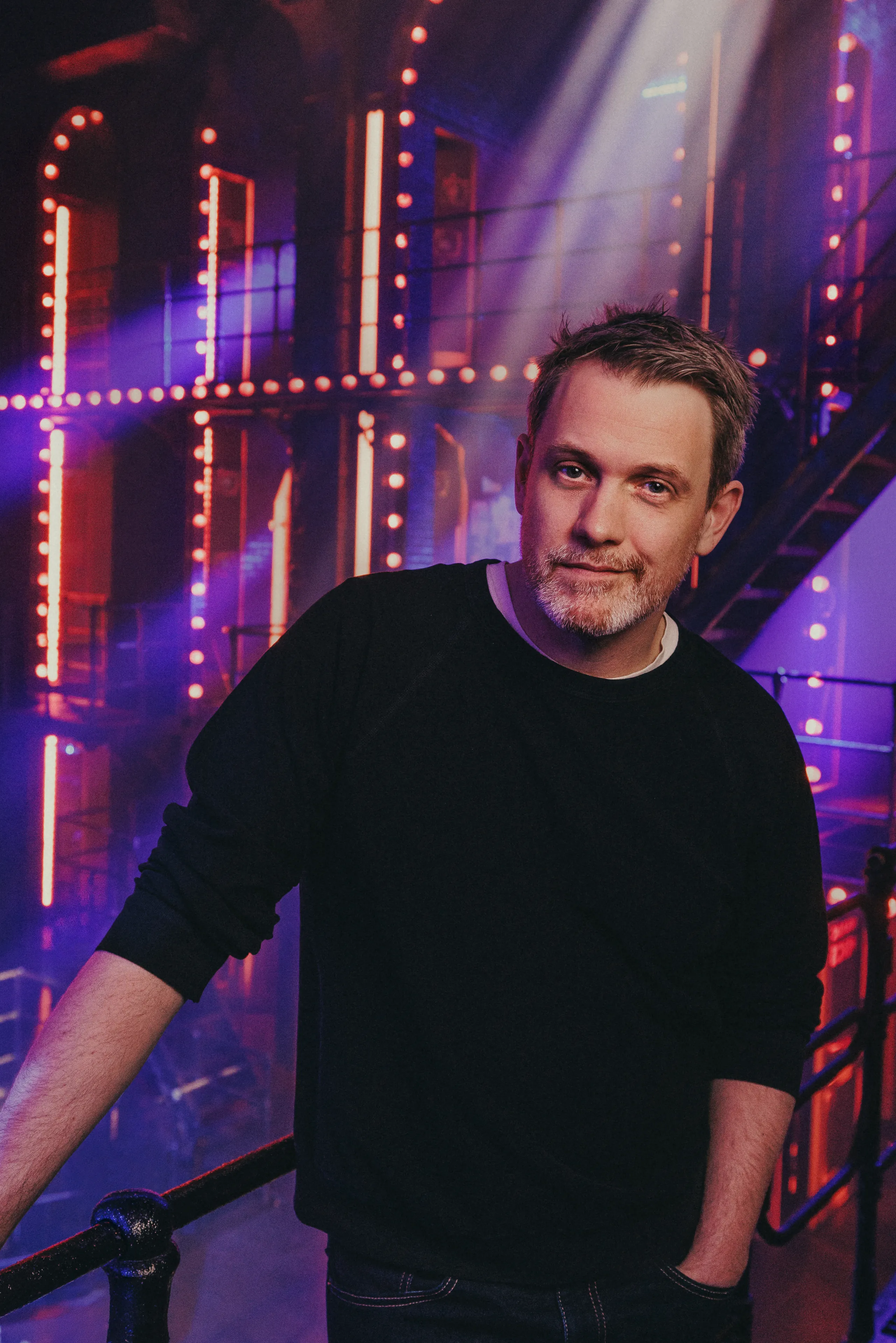 Image may contain Michael Arden Lighting Adult Person Urban Performer Solo Performance Face Happy Head and Smile
