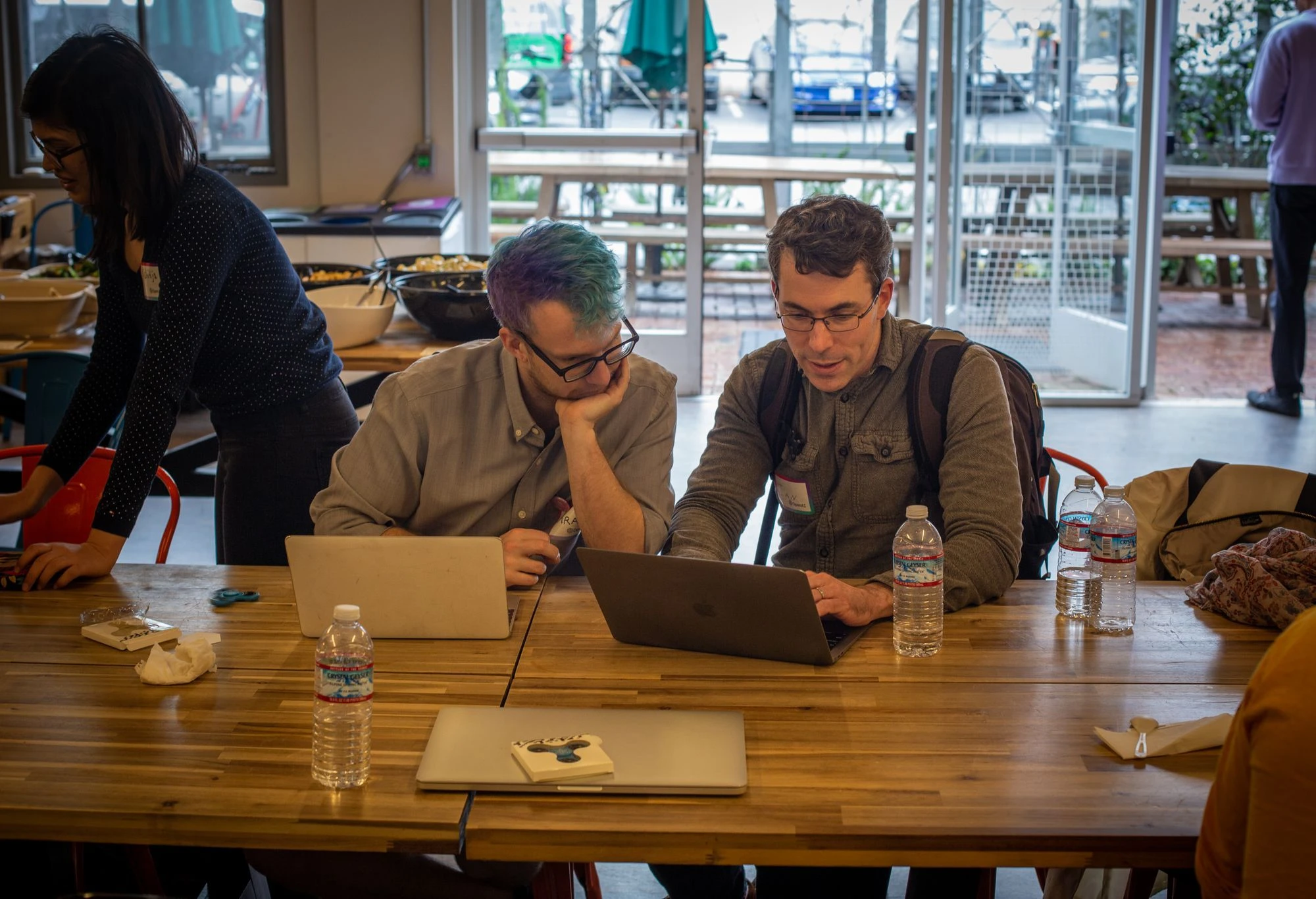 Two people working together on their laptops