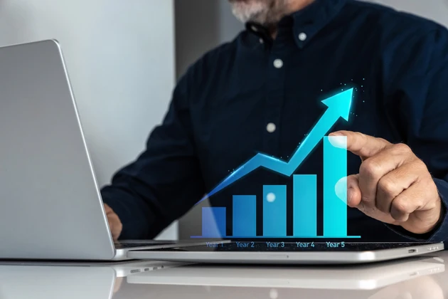 Businessman analyzing a five-year business growth plan with an ascending arrow chart