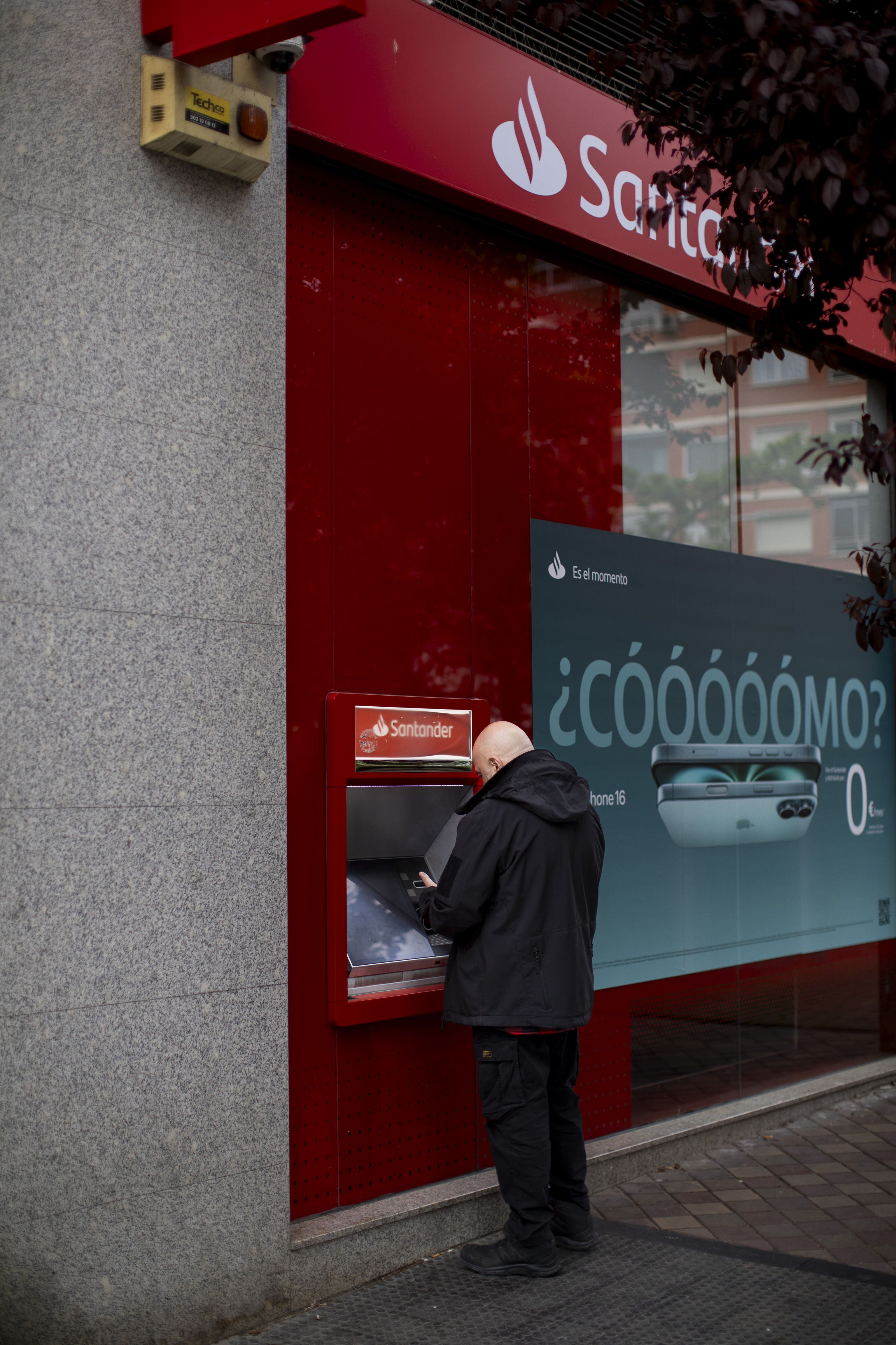 Un hombre saca dinero en un cajero del Banco Santander.