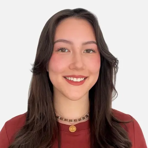A smiling young woman wi…inst a blue background.