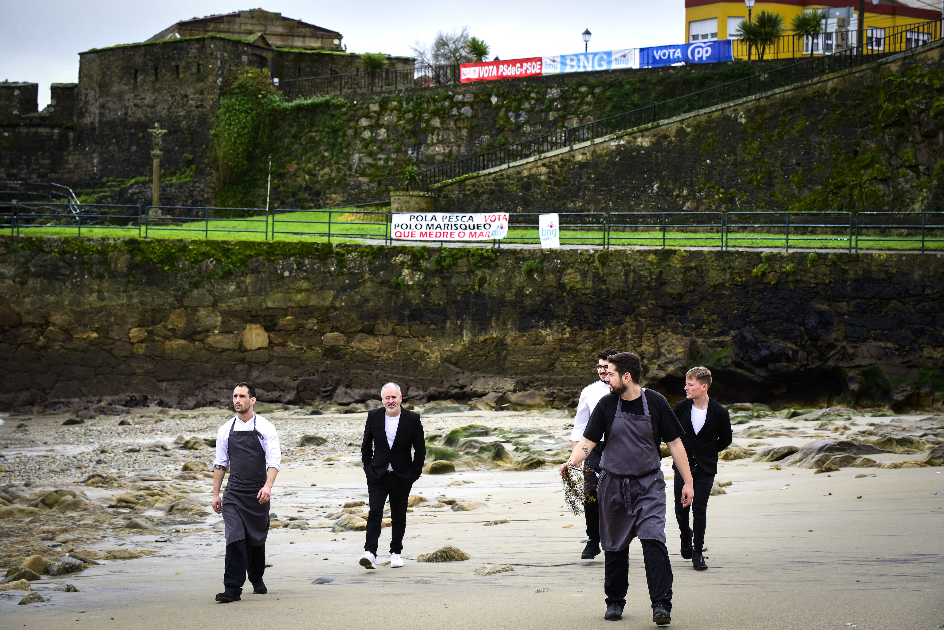 Brais (con camiseta negra y en primer plano a la dcha.) con su equipo en la playa de A Ribeira, frente a la que est� su restaurante.