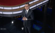 Stephen Colbert holds his hands in prayer while hosting "The Late Show."