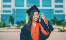 People lifting their graduation caps to the sky.