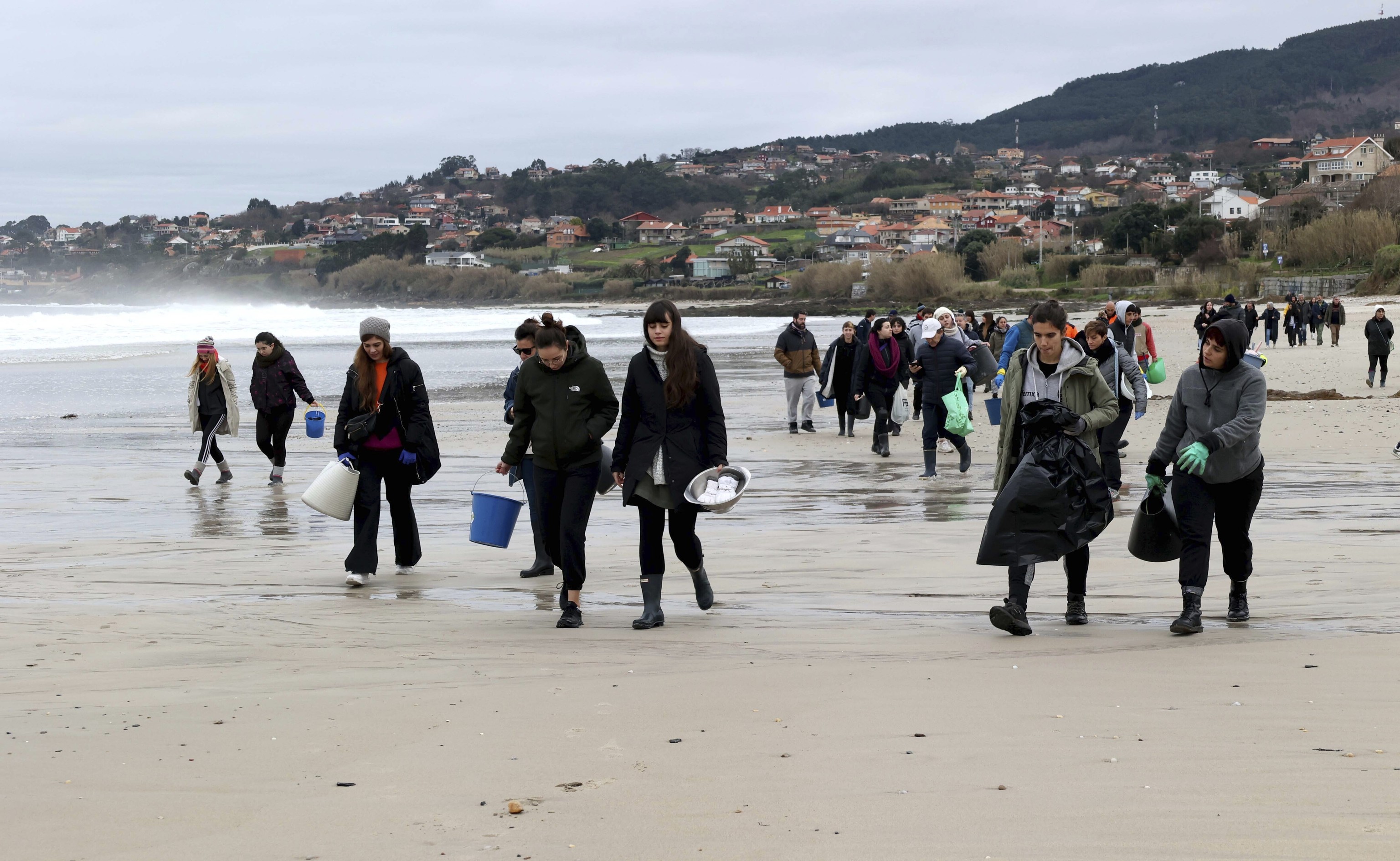 Voluntarios recogen pellets en Pontevedra.