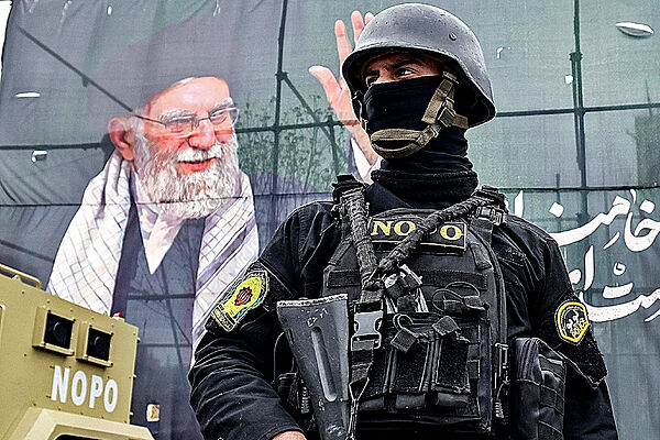 Un miembro de las fuerzas de seguridad iraníes junto a una pancarta del ayatolá Ali Jamenei, en Teherán.