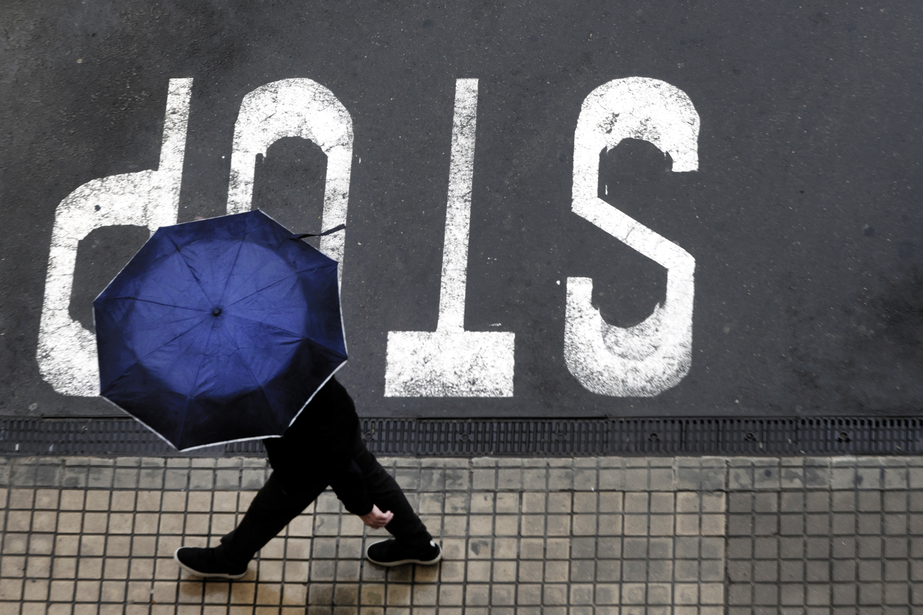 Un hombre camina bajo la lluvia.