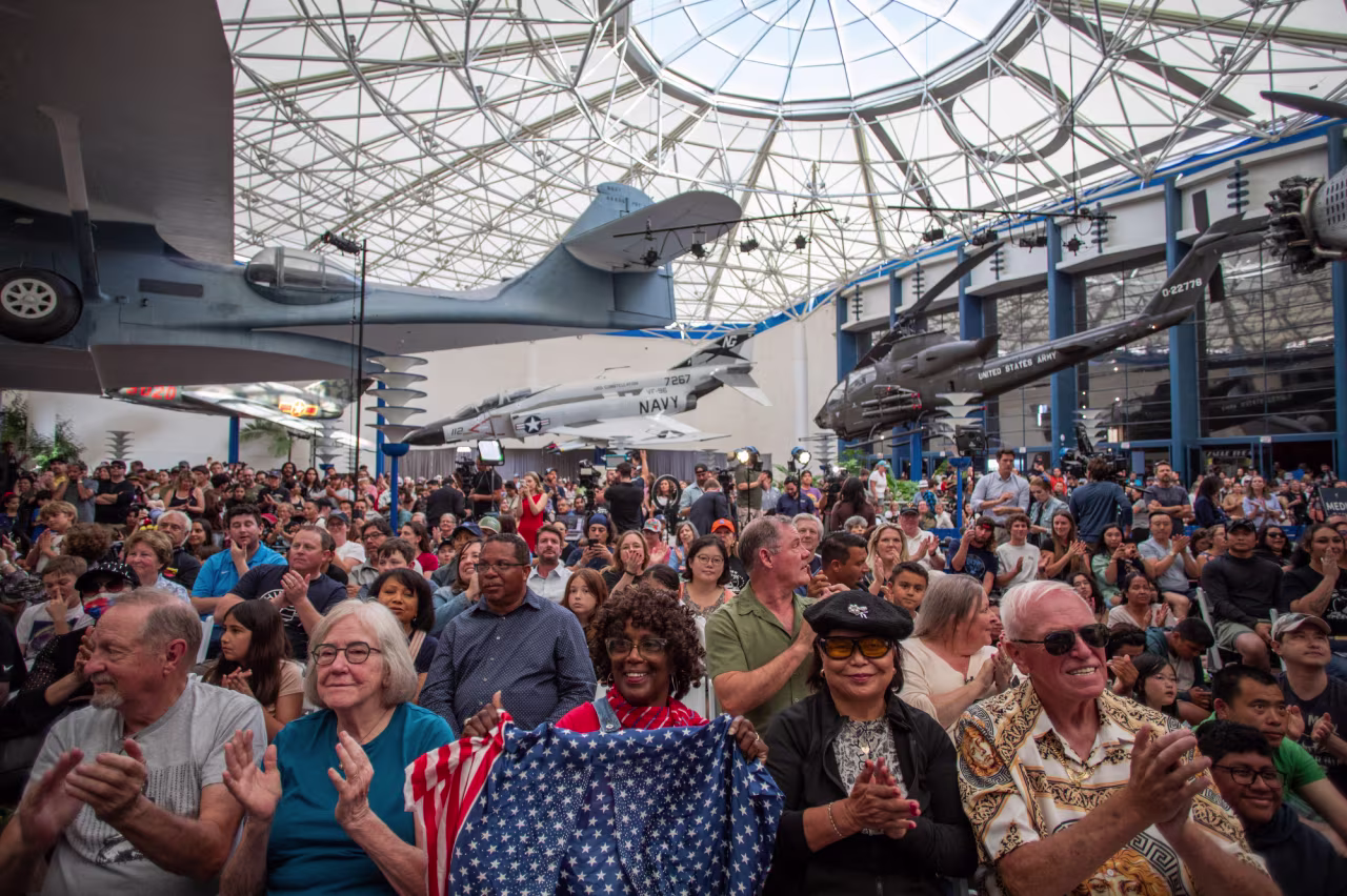 People watch a live broadcast of the return of the Artemis II crew to Earth at the San Diego Air and Space Museum during a watch party on Friday.