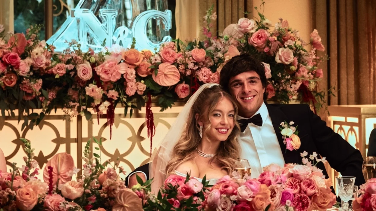 A couple smile at a lavish wedding surrounded by roses in a still from "Euphoria."