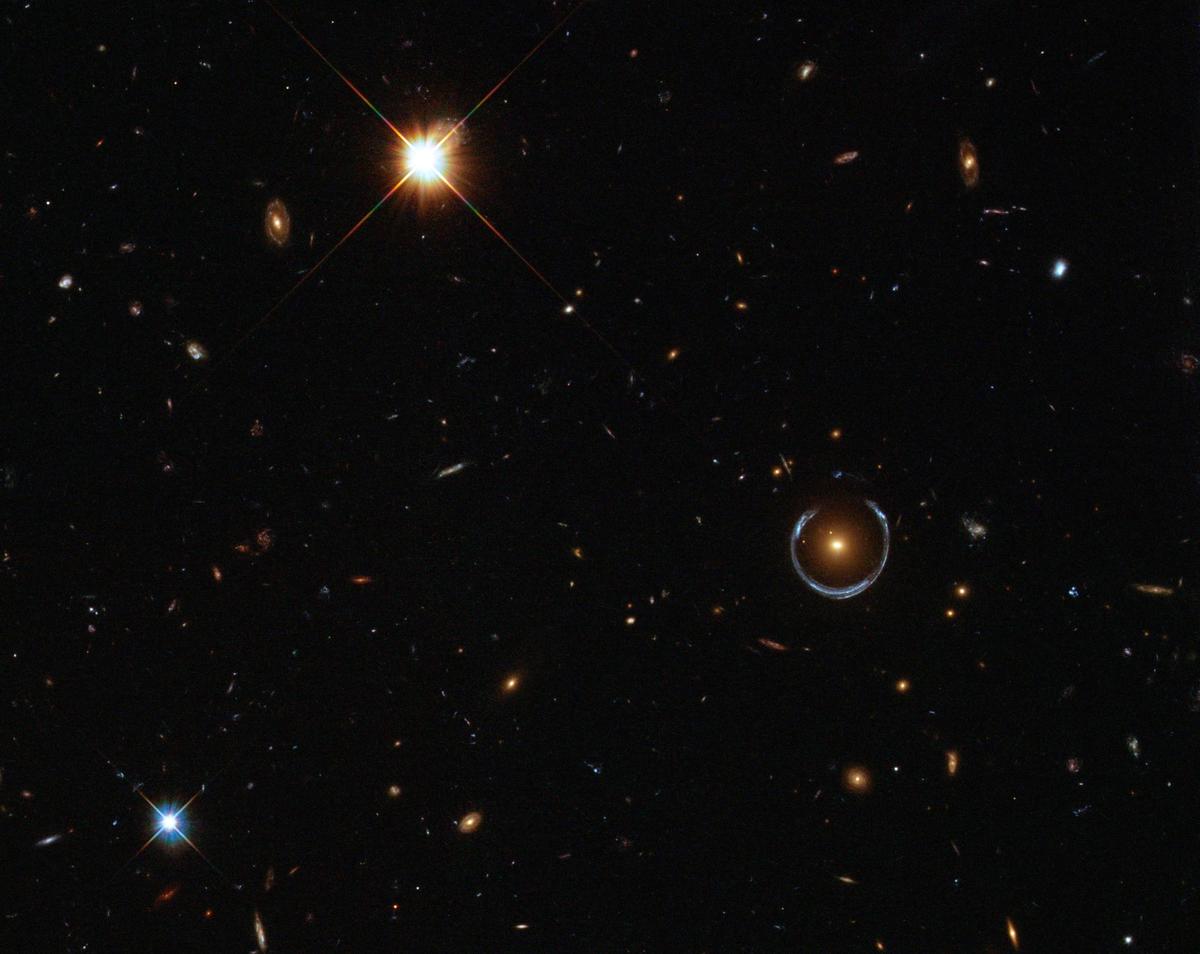 The blue horseshoe shape that circumscribes the red galaxy is the real prize in this image - an Einstein ring. This blue horseshoe is a distant galaxy that has been magnified and warped into a nearly complete ring by the strong gravitational pull of the massive foreground Luminous Red Galaxy.