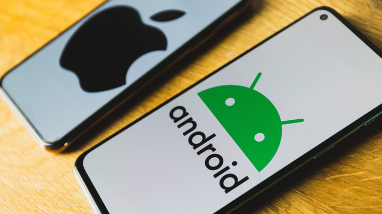Android and iOS phones side by side on table with logos on screens