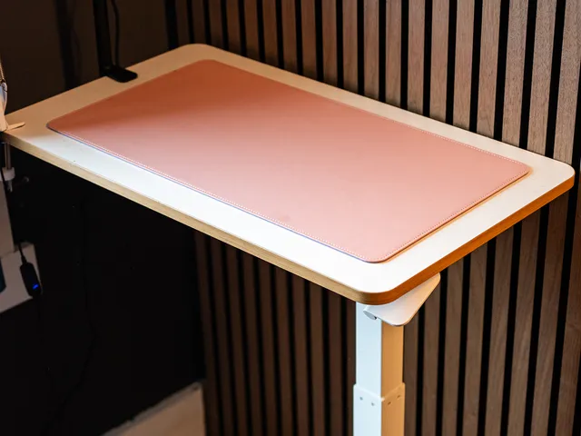 Flexispot Adjustable Table a raised white platform with one leg on the right leading to a crossbar with wheels on the bottom