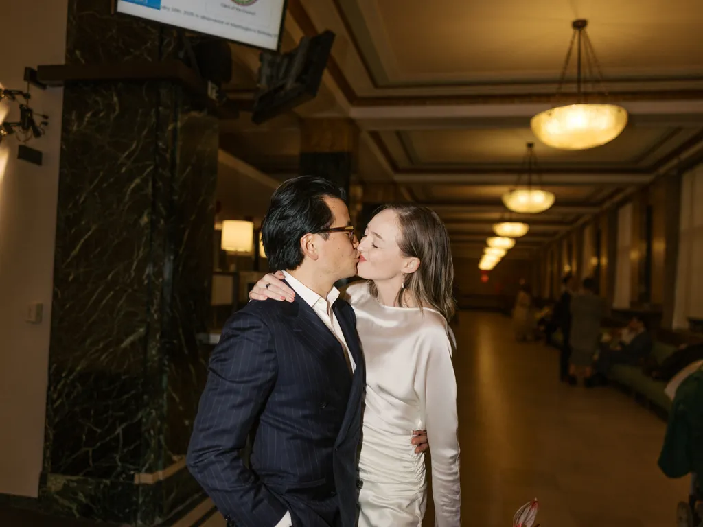 Image may contain Blazer Clothing Coat Jacket Lighting Formal Wear Suit Kissing Person Romantic Face and Head