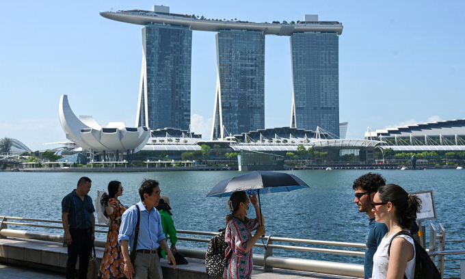 People walk along the Marina Bay waterfront in Singapore on May 25, 2023. Photo by AFP