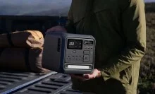 the DJI Power 1000 Mini being carried by a person who's standing near a truck outside