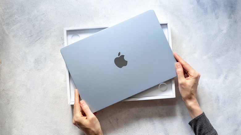 A person unboxing a MacBook.