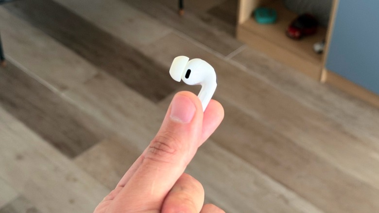 A hand holding one AirPods Pro 3 earbud