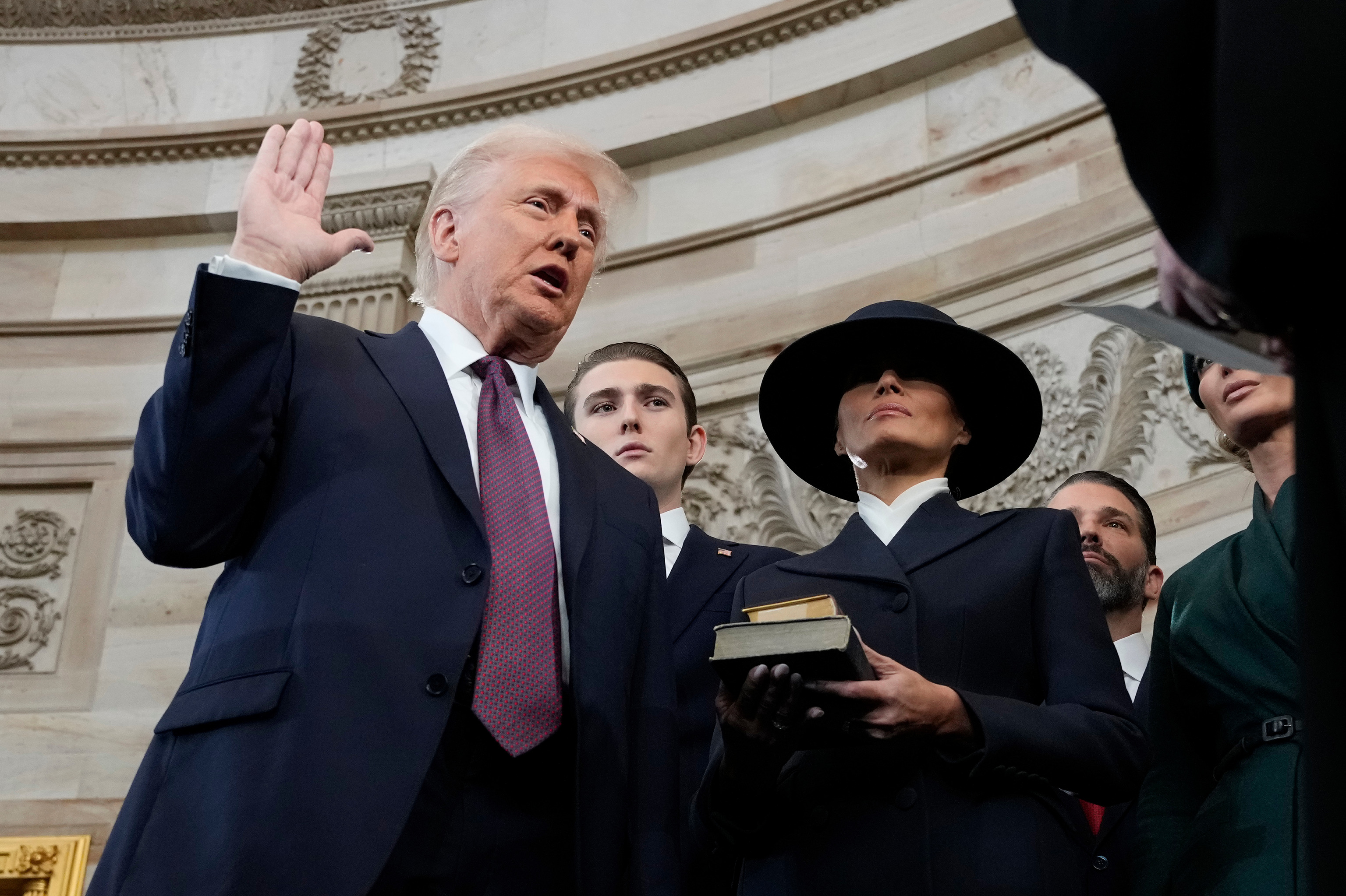 Trump jurando el cargo de presidente mientras Melania le sujeta la Biblia