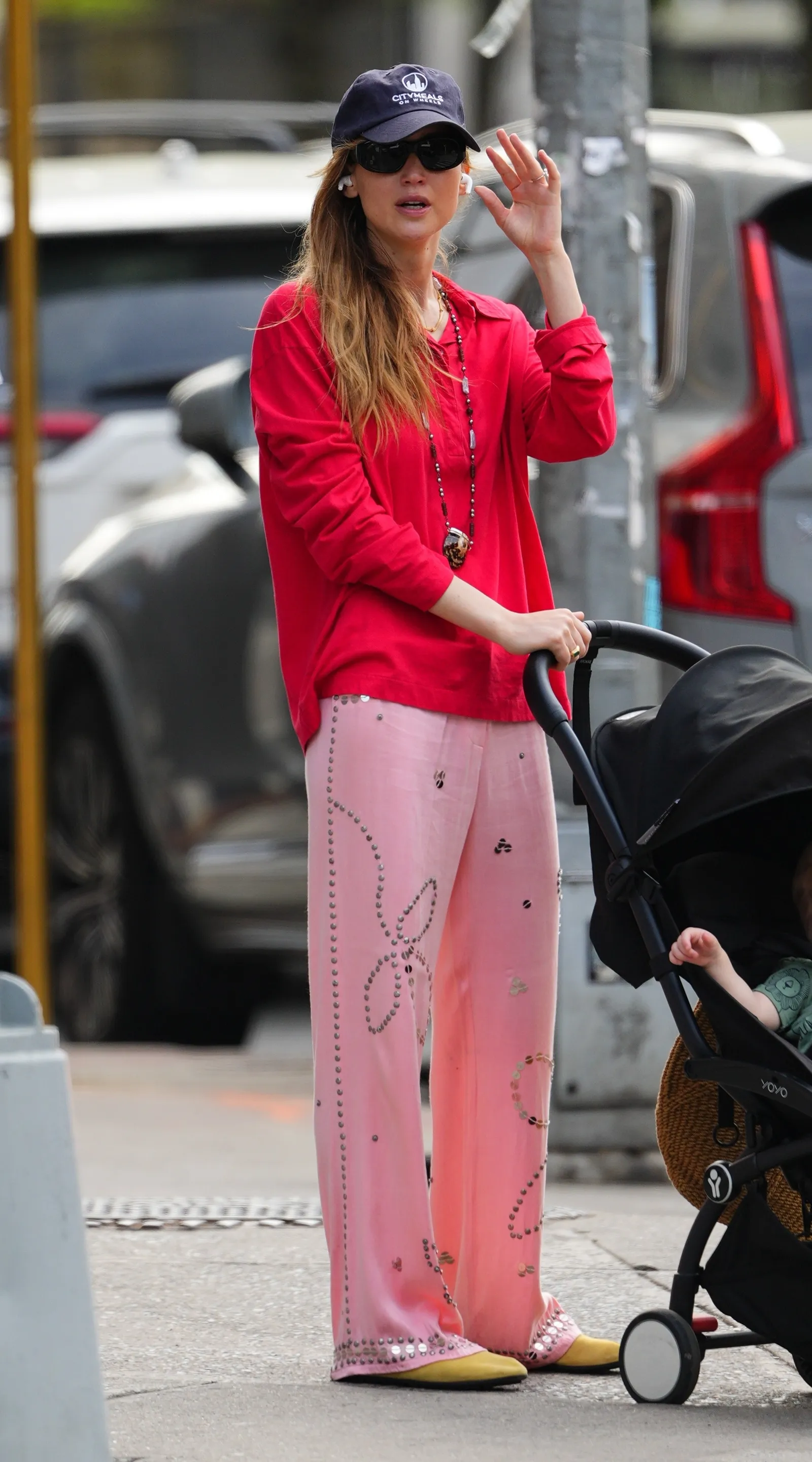 New York NY Actress Jennifer Lawrence brightens the NYC streets as she strolls with her baby in a red buttonup shirt and...
