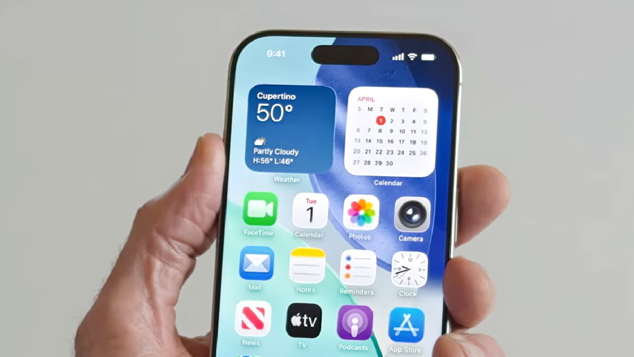 A person holding an iPhone running iOS 26.