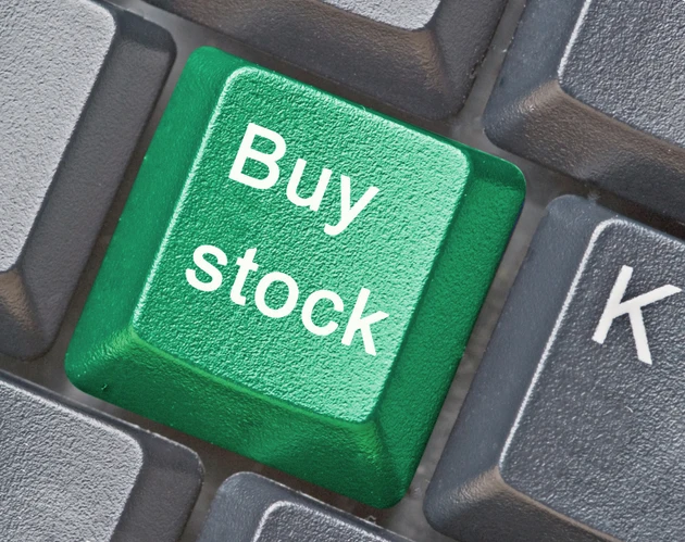 Close-up of a green buy stock button on a black keyboard