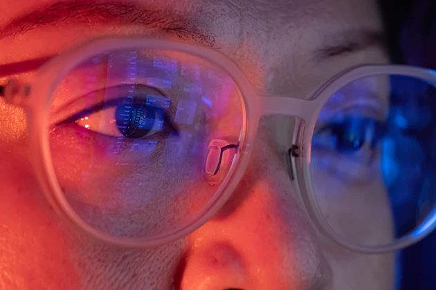 close up asian woman looking at computer screen with digital data information