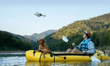 man and dog in kayak with DJI Mini 3 drone hovering overhead